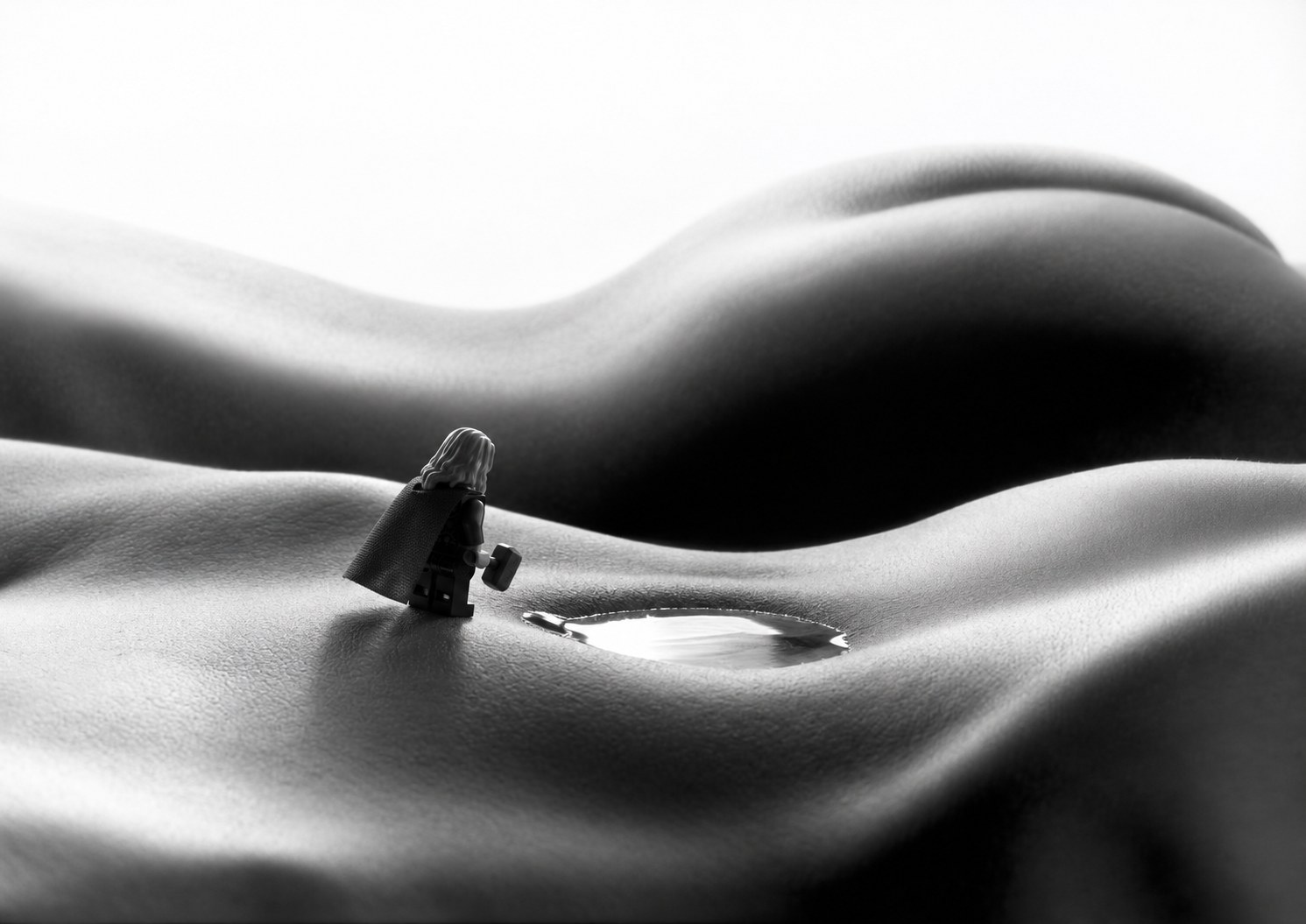 The figure stops at the edge of a navel filled with light