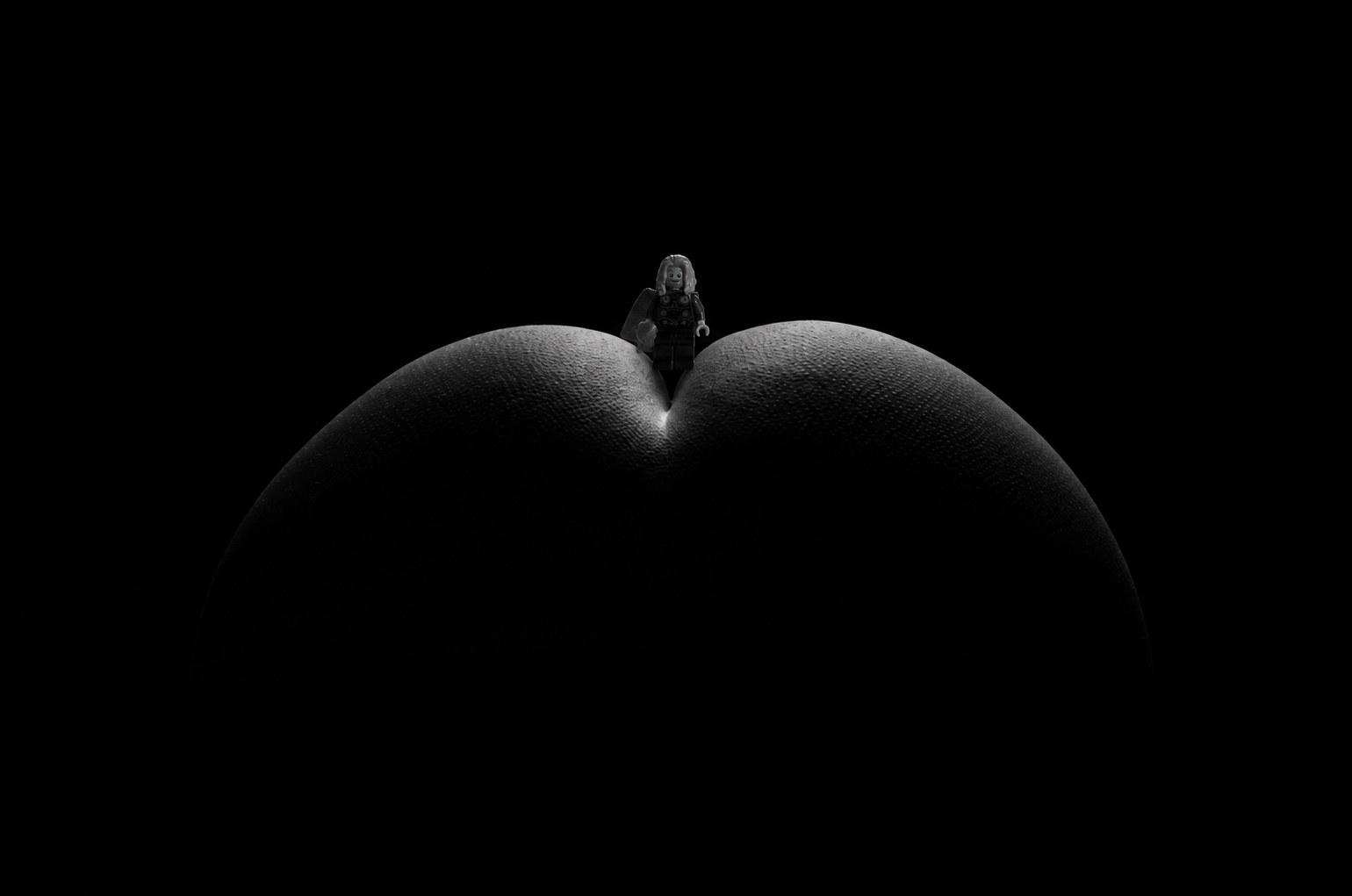 A minute silhouette on a ridge, nearly drowned in black
